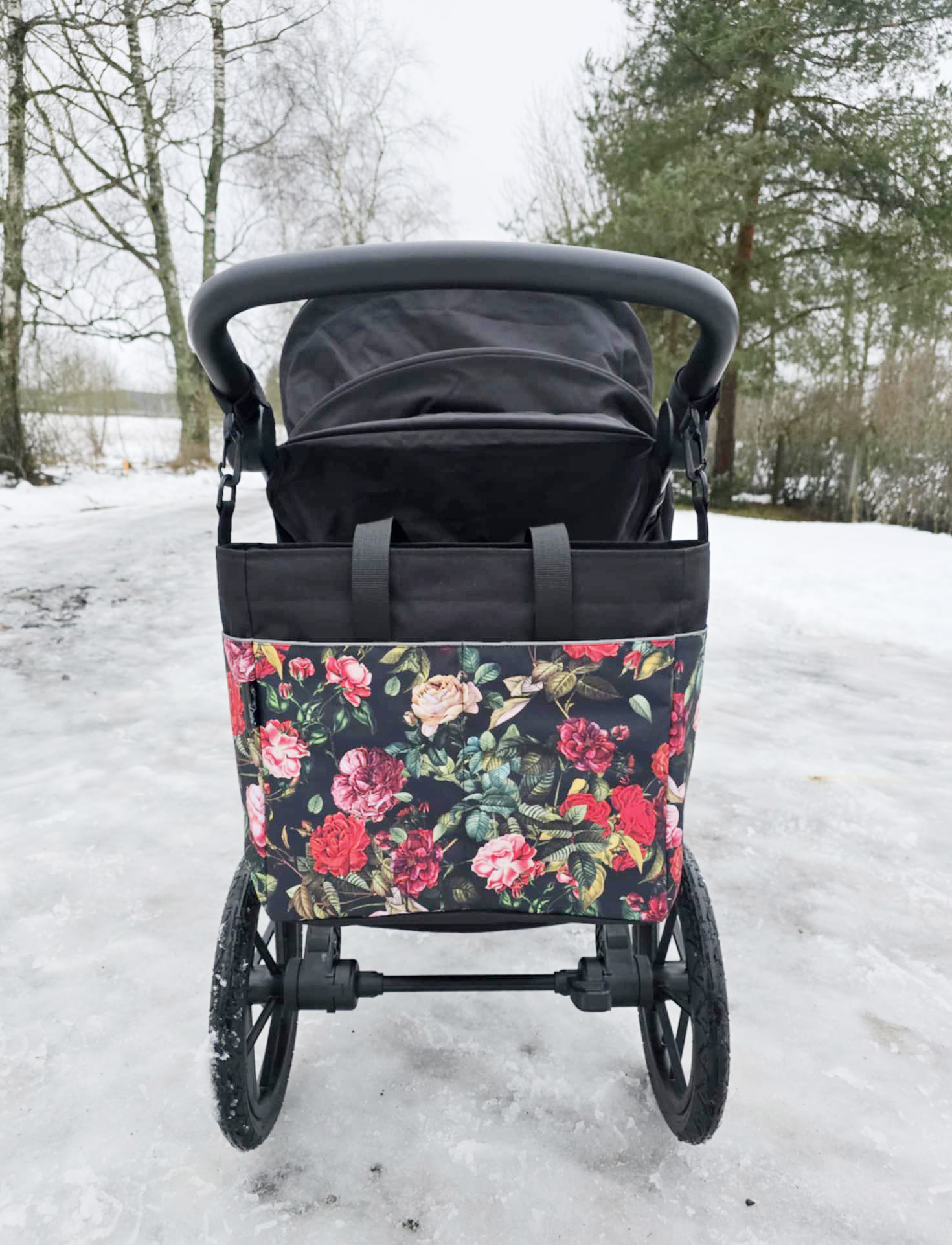 Näitab, kuidas näeb välja roosimustriline vankrikott käru küljes välja. Lumi on maas. Käru on tagantvaates.
